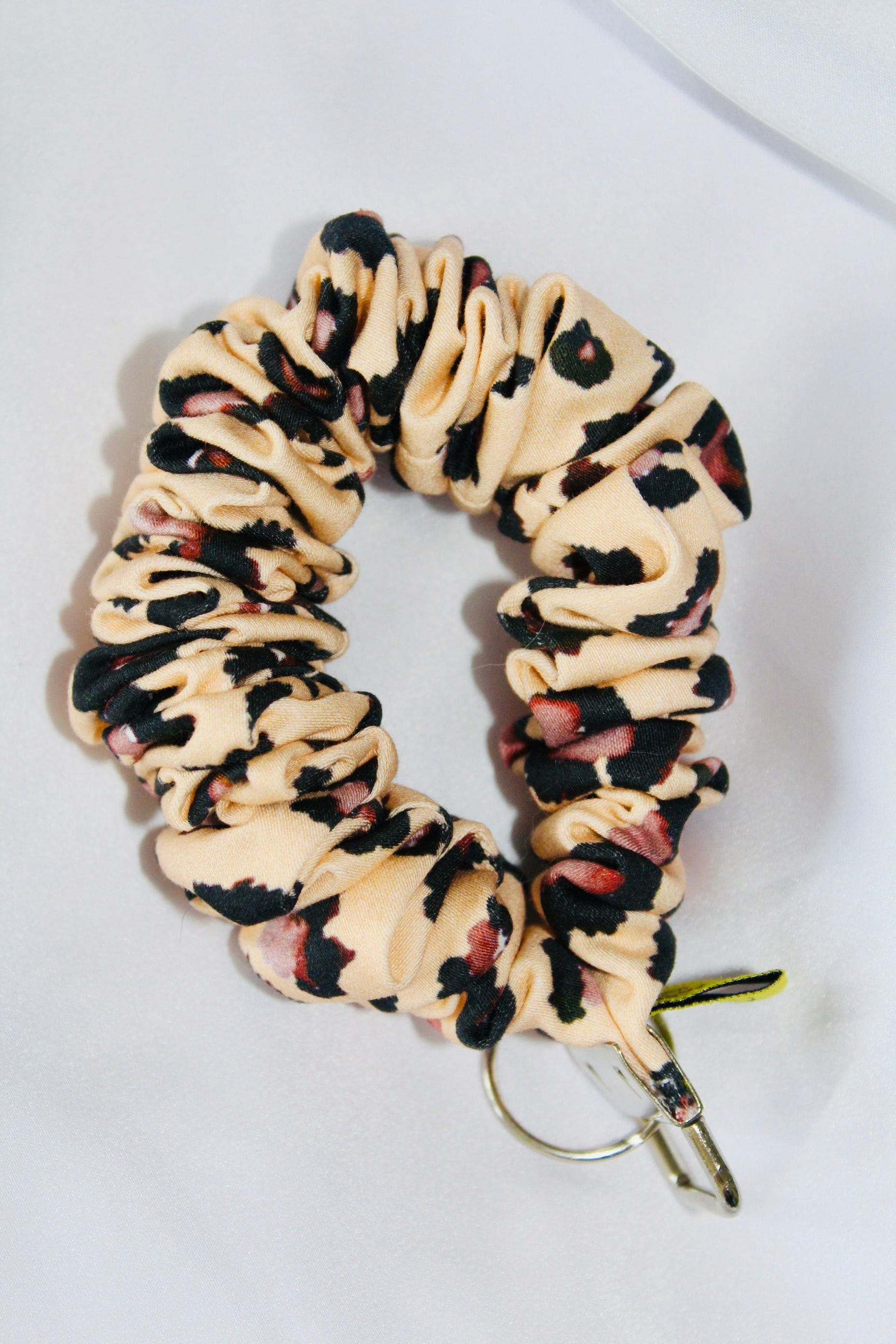This is a cream and brown leopard print cotton scrunchie that is a keyring. Ensuring your keys are always to hand.