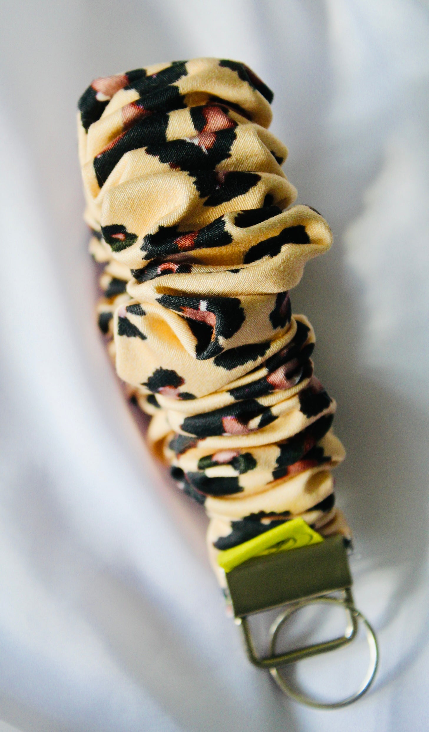 This is a cream and brown leopard print cotton scrunchie that is a keyring. Ensuring your keys are always to hand.