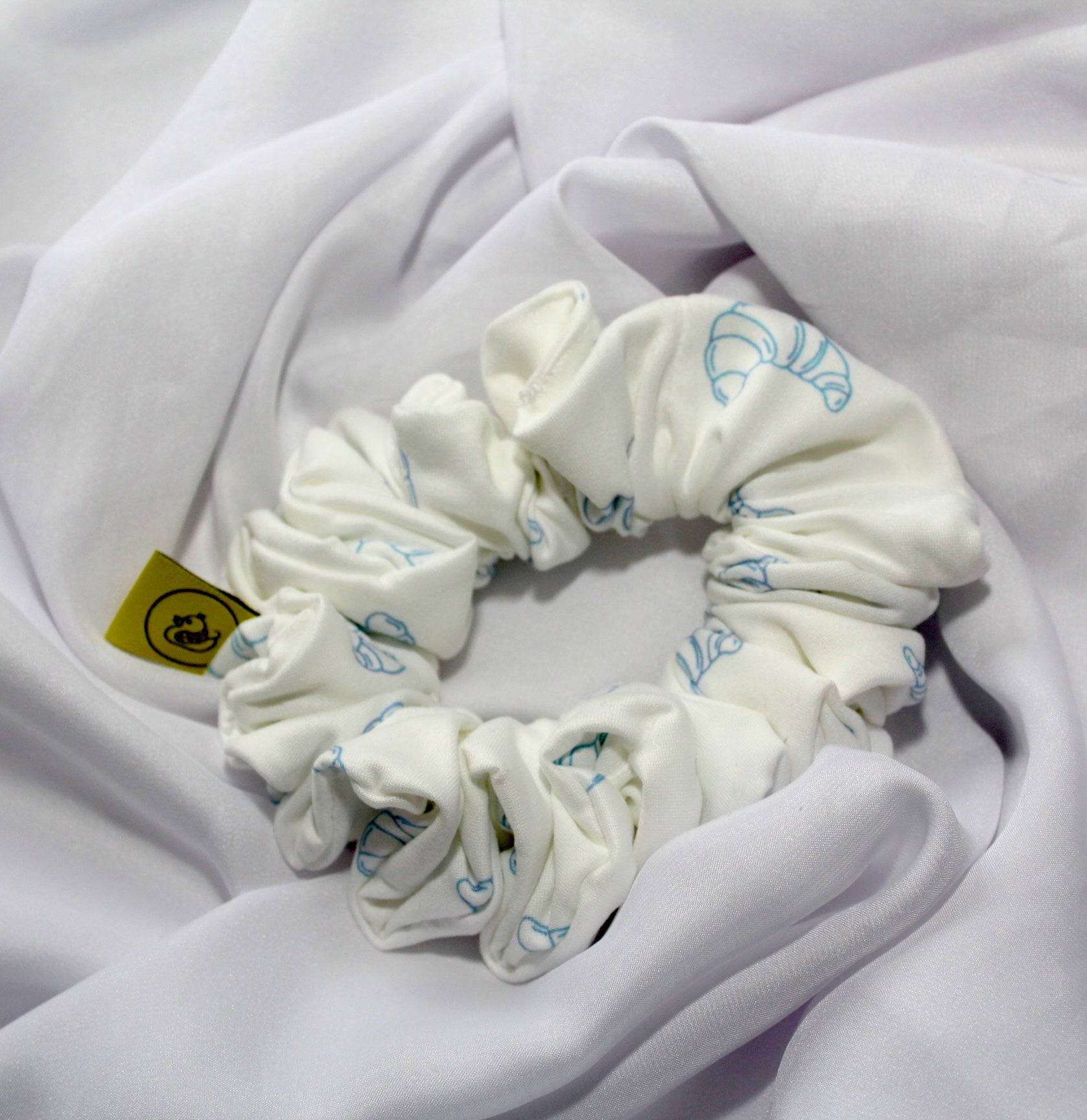 Handmade breakfast themed scrunchie pastel colours UK

Cute food inspired scrunchie handmade UK

Breakfast club hair scrunchie for ponytail styling

White Soft scrunchie with pastel blue Croissants