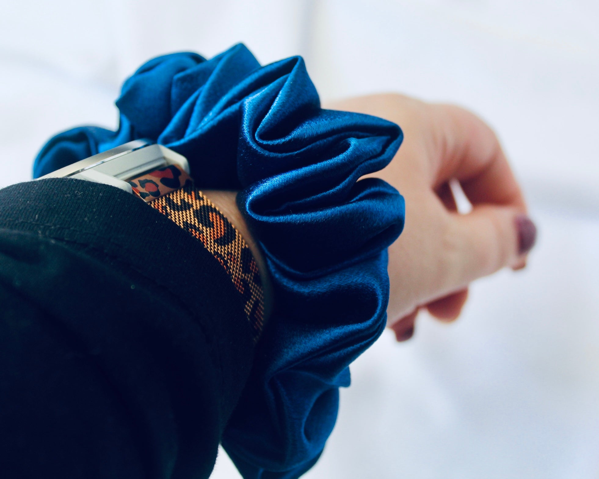 A satin scrunchie in a striking royal blue shade with a silky glossy texture and a ruched design.  Crafted from satin this scrunchie feels smooth and cool to the touch.  The bold royal blue colour stands out beautifully, making it a statement piece for both casual and evening looks.  The gathered satin fabric creates a full textured effect over the elastic ensuring a secure hold.