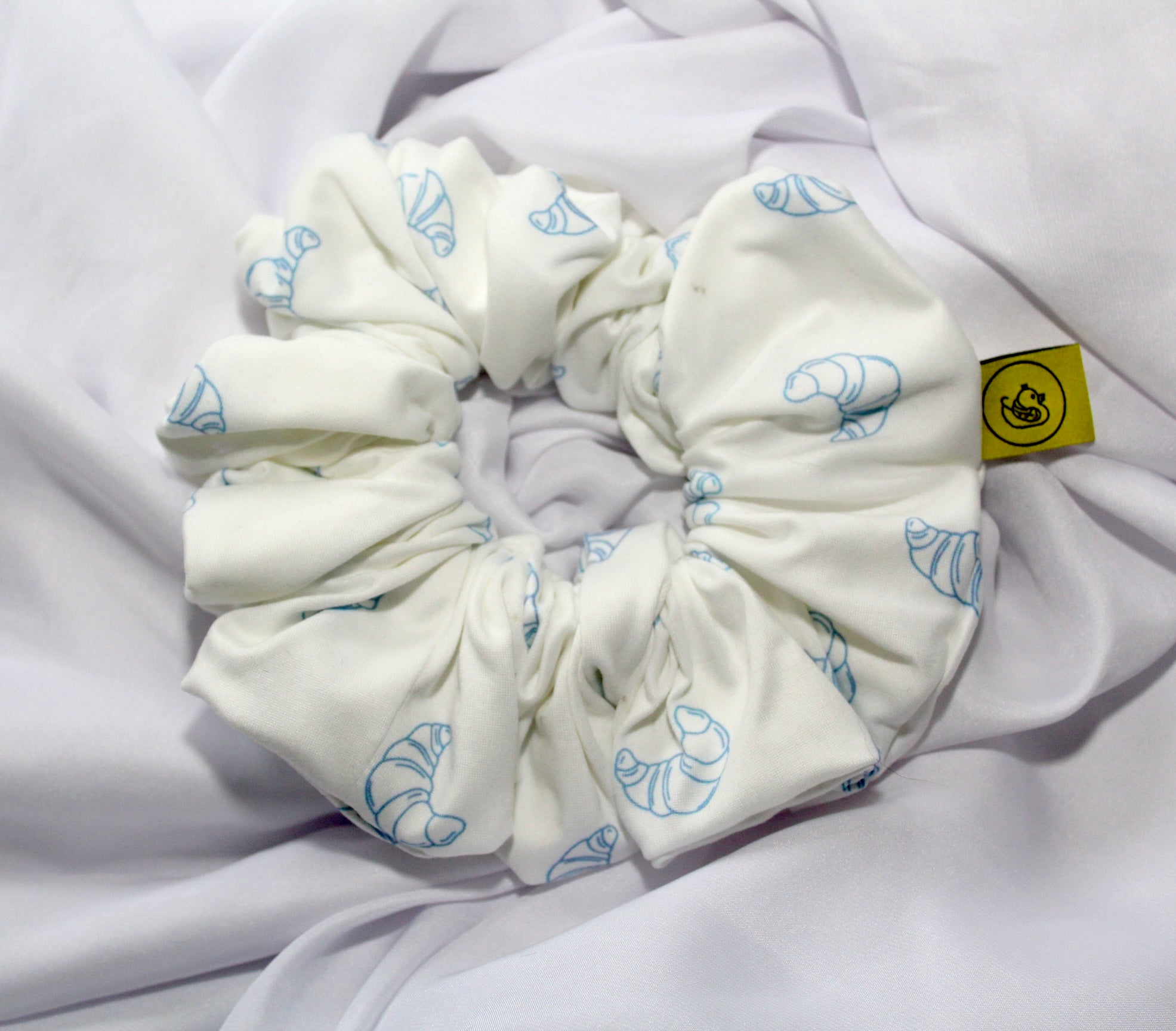 Handmade breakfast themed scrunchie pastel colours UK

Cute food inspired scrunchie handmade UK

Breakfast club hair scrunchie for ponytail styling

White Soft scrunchie with pastel blue Croissants